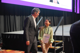 Ross Wimer, Senior Vice President, AECOM, congratulates the first place winner of the student design competition.